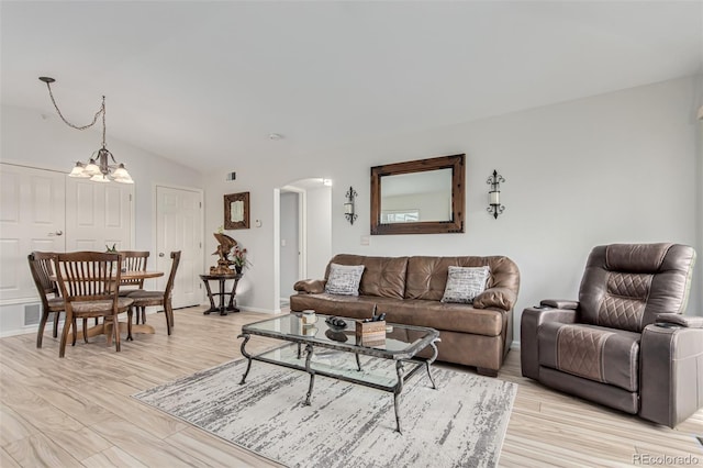 living room with light hardwood / wood-style floors and an inviting chandelier