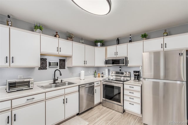 kitchen featuring light hardwood / wood-style flooring, stainless steel appliances, white cabinetry, and sink