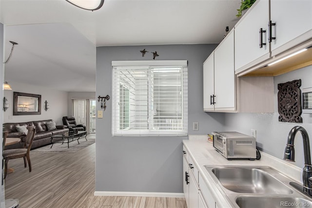 kitchen with sink, white cabinets, and light hardwood / wood-style floors