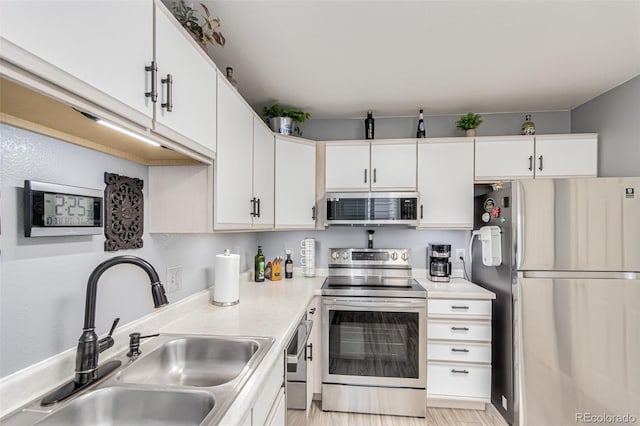 kitchen with white cabinets, stainless steel appliances, and sink