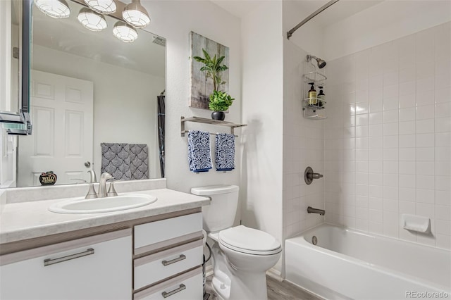 full bathroom with toilet, vanity, hardwood / wood-style floors, and tiled shower / bath