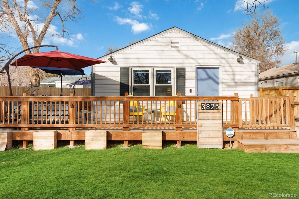 back of house with a deck and a yard