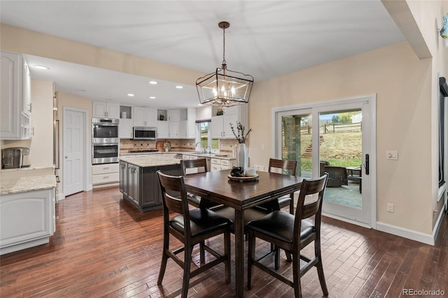 dining area with dark hardwood / wood-style floors and a notable chandelier