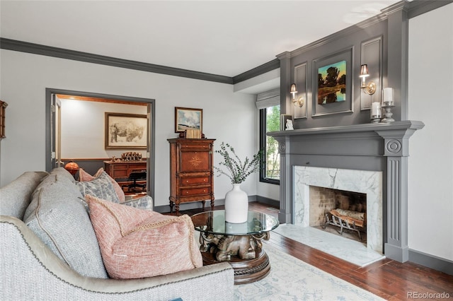 living room featuring a fireplace, crown molding, and dark wood-type flooring