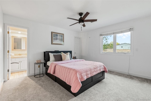 bedroom with light carpet, ensuite bath, and ceiling fan