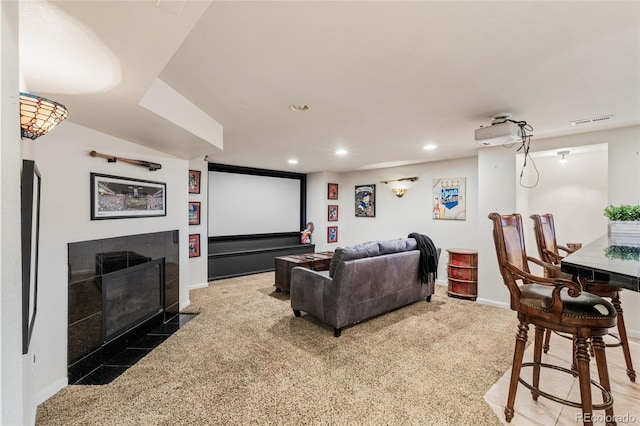 home theater featuring a tiled fireplace and carpet