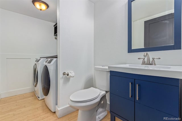 4935 Apollo Bay Dr, Highlands Ranch, CO 80130 - bathroom featuring washer and dryer, wood finished floors, vanity, and toilet