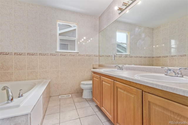 4935 Apollo Bay Dr, Highlands Ranch, CO 80130 - bathroom with tile walls, tile patterned flooring, double vanity, a bathtub, and toilet