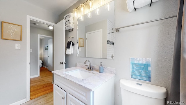 bathroom featuring hardwood / wood-style floors, vanity, and toilet