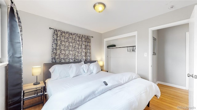 bedroom with wood-type flooring and a closet