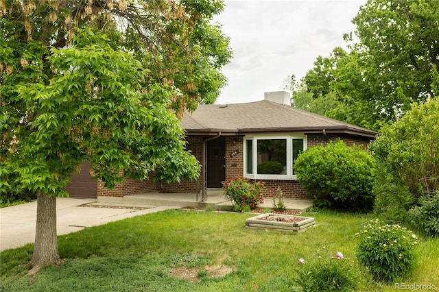 654 S Shoshone St, Denver, CO 80223 - view of front of home featuring brick siding, concrete driveway, a front yard, and an attached garage