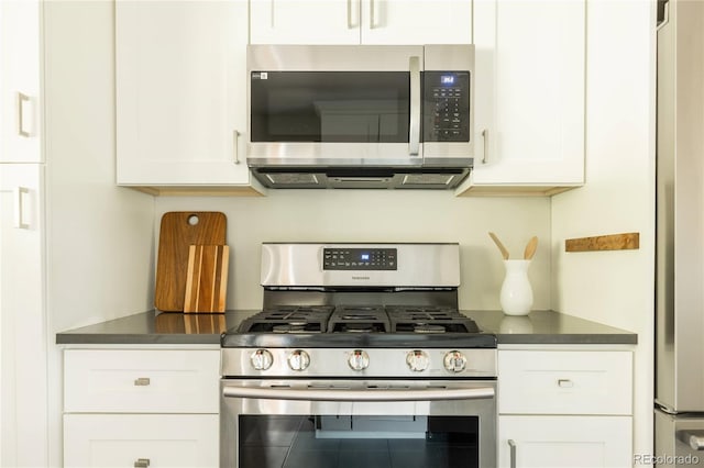 654 S Shoshone St, Denver, CO 80223 - kitchen with stainless steel appliances, dark countertops, and white cabinets