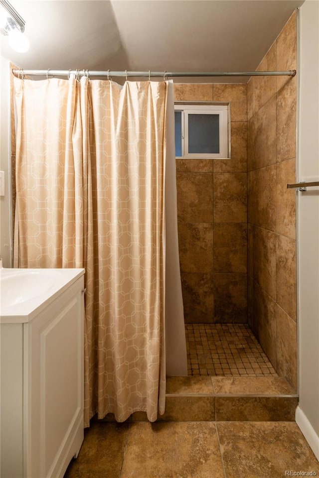 654 S Shoshone St, Denver, CO 80223 - bathroom with a tile shower and vanity