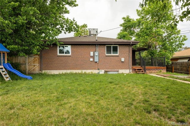 654 S Shoshone St, Denver, CO 80223 - rear view of property featuring brick siding, a wooden deck, and a playground