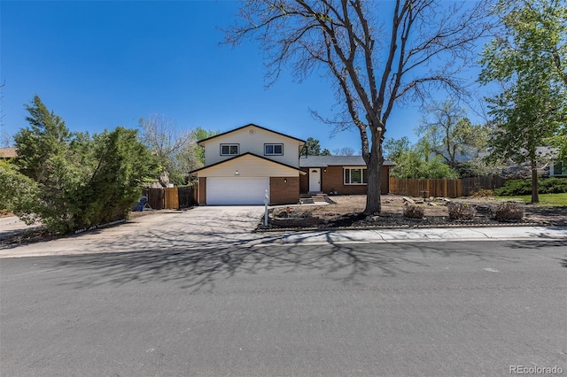3256 S Nucla St, Aurora, CO 80013 - view of front of house with fence, concrete driveway, brick siding, and an attached garage