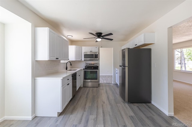 3256 S Nucla St, Aurora, CO 80013 - kitchen featuring stainless steel appliances, a sink, light countertops, light wood-style flooring, and a ceiling fan