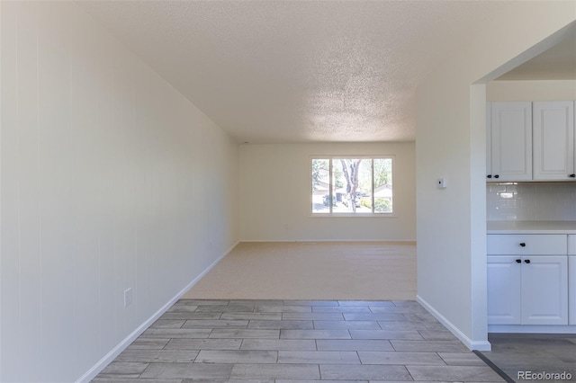 3256 S Nucla St, Aurora, CO 80013 - unfurnished dining area featuring a textured ceiling, wood tiled floors, and baseboards