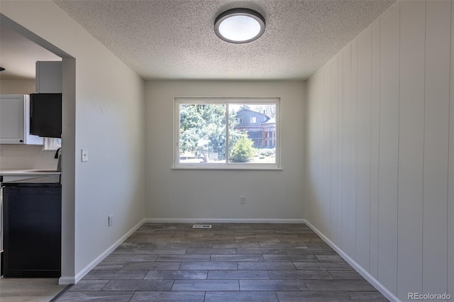 3256 S Nucla St, Aurora, CO 80013 - unfurnished dining area with wood finished floors, a textured ceiling, a sink, and baseboards