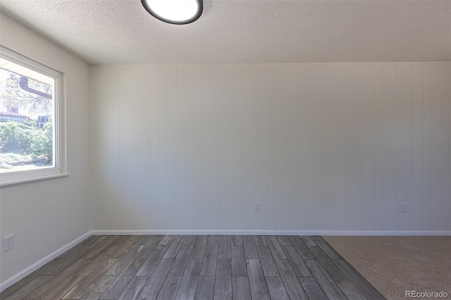 3256 S Nucla St, Aurora, CO 80013 - empty room featuring dark wood finished floors, a textured ceiling, and baseboards