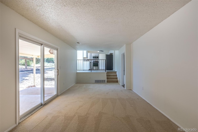 3256 S Nucla St, Aurora, CO 80013 - spare room with light carpet, a textured ceiling, stairs, and baseboards