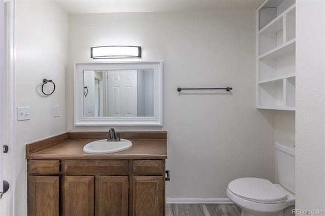 3256 S Nucla St, Aurora, CO 80013 - bathroom featuring wood finished floors, toilet, vanity, and baseboards