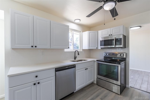3256 S Nucla St, Aurora, CO 80013 - kitchen featuring appliances with stainless steel finishes, a sink, light wood-style floors, ceiling fan, and white cabinets