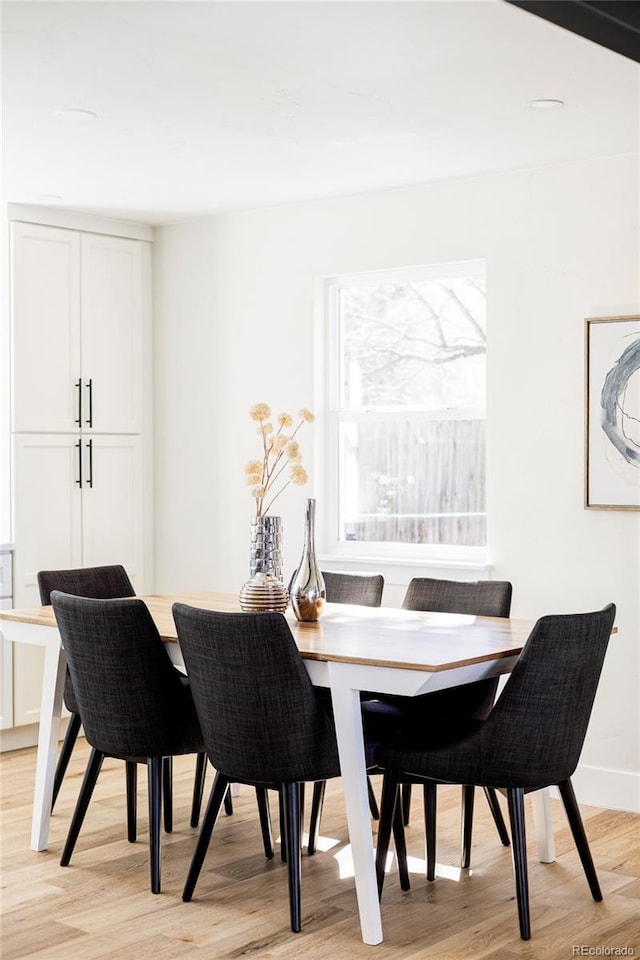 dining room featuring light wood-style floors and baseboards