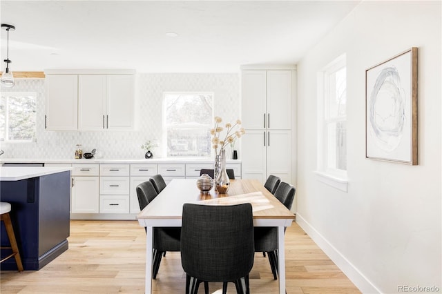 dining space with plenty of natural light, light wood-type flooring, and baseboards