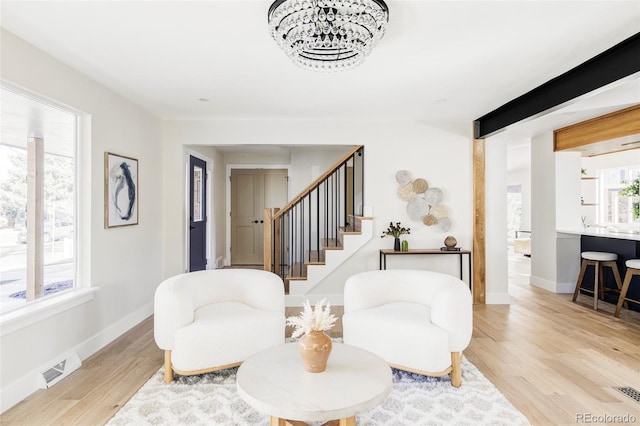 living area featuring stairway, wood finished floors, and baseboards