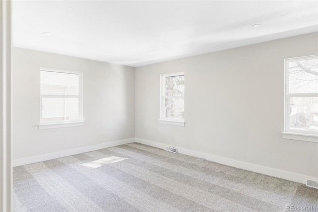 carpeted spare room featuring baseboards