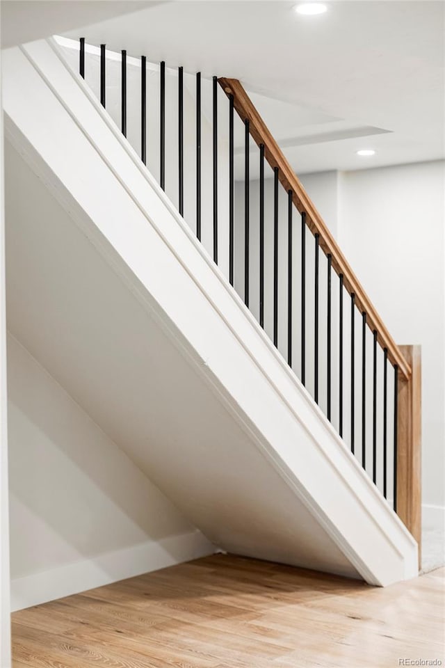 stairway with wood finished floors, recessed lighting, and baseboards