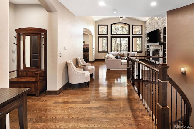 corridor featuring an upstairs landing, wood finished floors, and vaulted ceiling