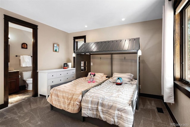 bedroom featuring recessed lighting, baseboards, ensuite bathroom, and dark carpet