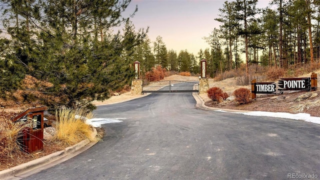 view of street featuring curbs and a gate