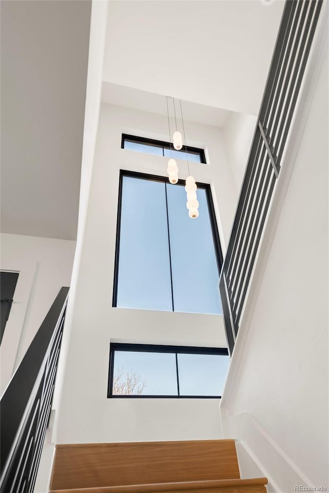 stairway featuring a towering ceiling