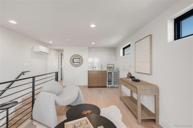 sitting room featuring bar area, beverage cooler, a wall mounted AC, and light wood-type flooring