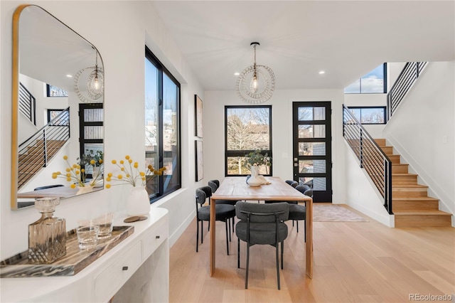 dining space featuring a healthy amount of sunlight, a chandelier, and light hardwood / wood-style floors