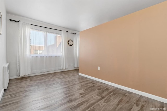 spare room with light wood-type flooring and radiator