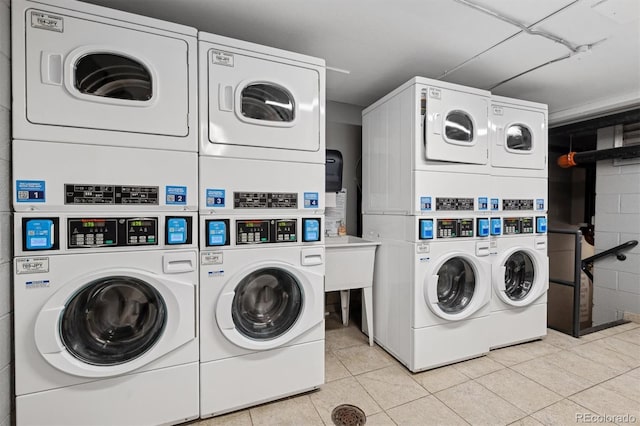 laundry room featuring stacked washing maching and dryer, washer and clothes dryer, and light tile patterned floors