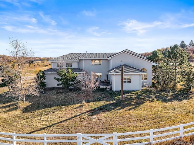 view of front of house with a front lawn and a rural view