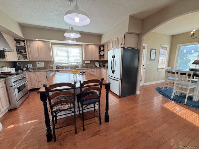 595 W Oak Hill Ln, Castle Rock, CO 80108 - kitchen with stainless steel appliances, open shelves, arched walkways, plenty of natural light, and a textured ceiling