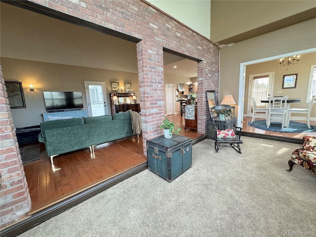 595 W Oak Hill Ln, Castle Rock, CO 80108 - living room with a chandelier, decorative columns, a high ceiling, and wood finished floors