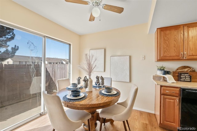 dining area with light wood-style flooring, baseboards, and a ceiling fan