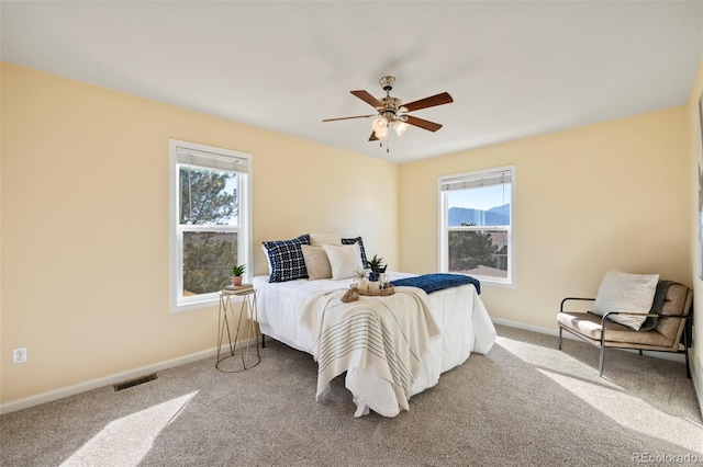 bedroom featuring baseboards, multiple windows, visible vents, and carpet floors