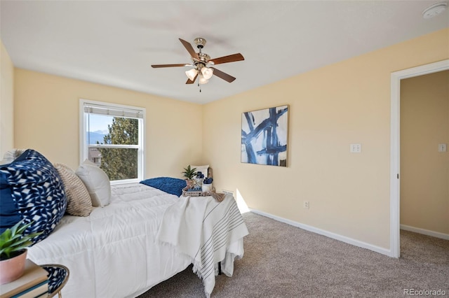 carpeted bedroom featuring baseboards and a ceiling fan