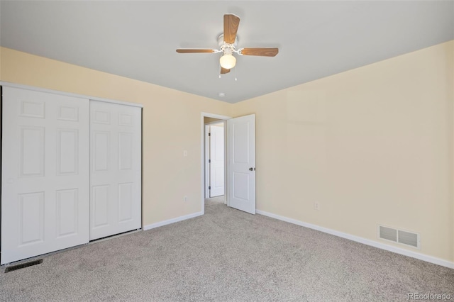 unfurnished bedroom with a closet, carpet flooring, visible vents, and baseboards