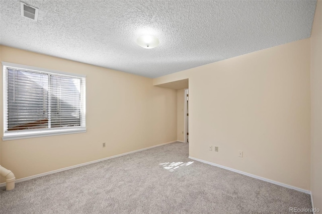 unfurnished room featuring a textured ceiling, carpet flooring, baseboards, and visible vents