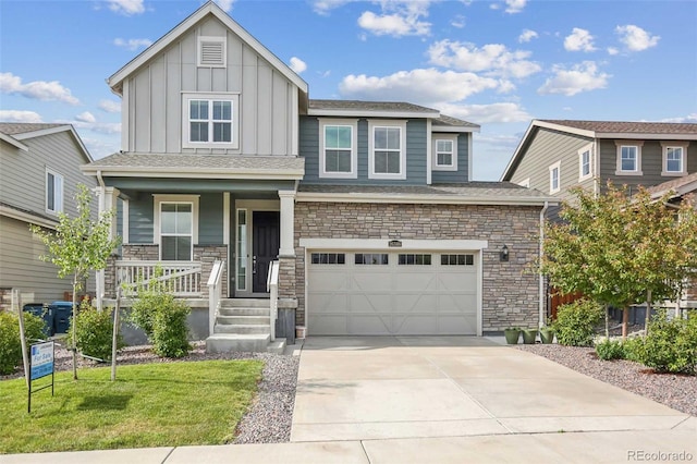 view of front of house featuring a garage, covered porch, and a front yard