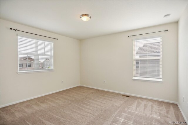 carpeted spare room featuring plenty of natural light