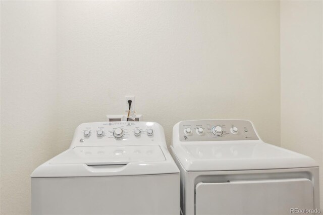 clothes washing area with washing machine and dryer